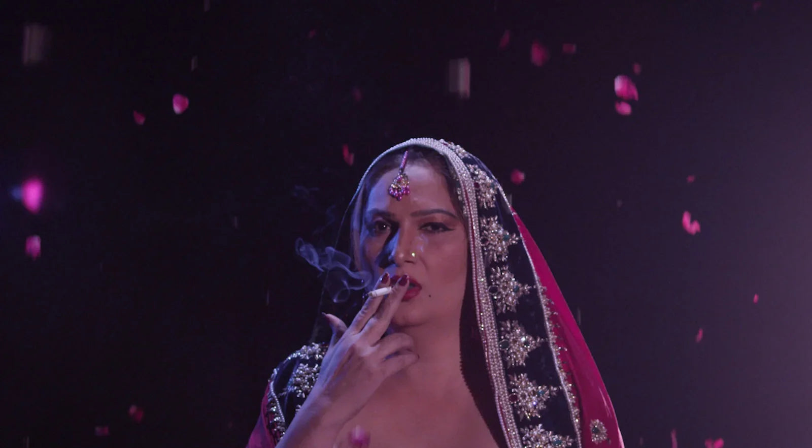 Woman in ornate traditional attire smoking, dramatic lighting, rose petals falling, Khajistan archive