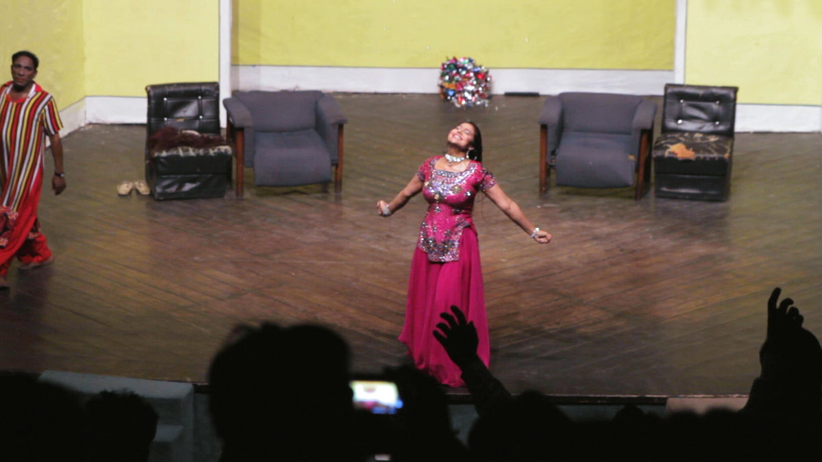 A dancer in magenta performs on stage in Showgirls of Pakistan